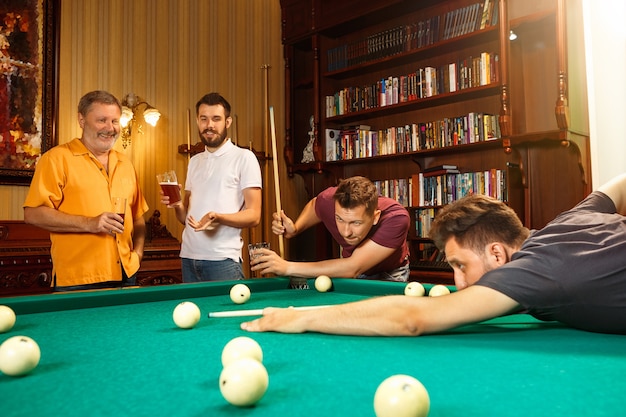 Close-up shot of a man playing billiard. caucasian model carefully and strenuously aiming by cue in ball. Game concept