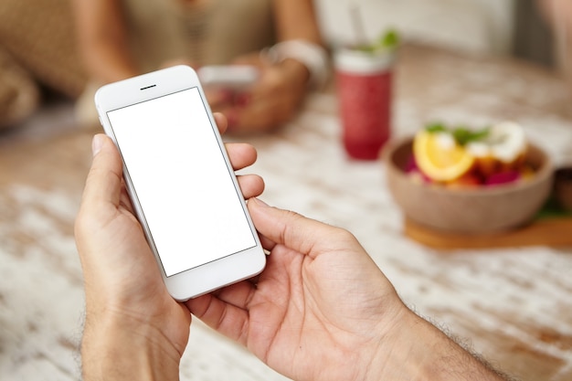 Close up shot of man's hands holding cell phone with blank copy space screen for your text.