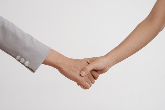 Free photo close-up shot of two unrecognizable women shaking hands in studio