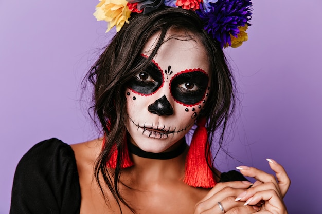 Free photo close-up shot of vampire woman wears colorful flower wreath. inspired caucasian girl posing in masquerade costume.