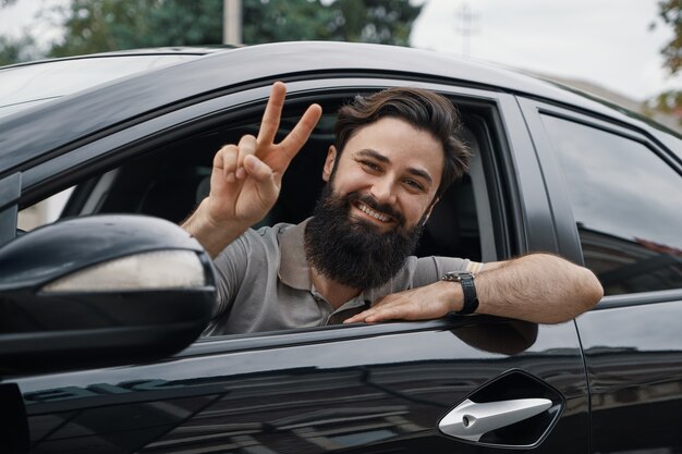 Close up side portrait of happy man driving car