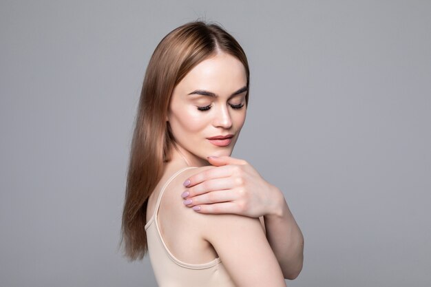 Close up side view of young woman standing isolated grey wall