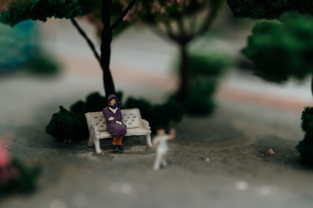 Free Photo close up of small people sitting in chairs in the park.