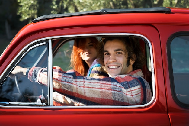 Close up smiley couple in red car