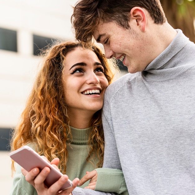 Free Photo close-up smiley couple with smartphone