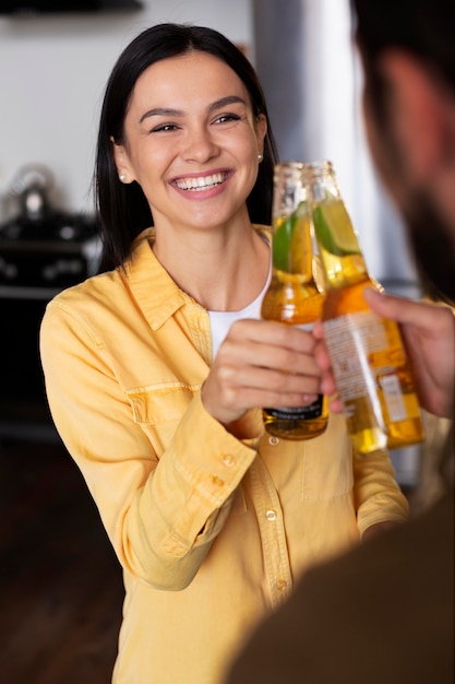 Close up smiley friends clinking bottles