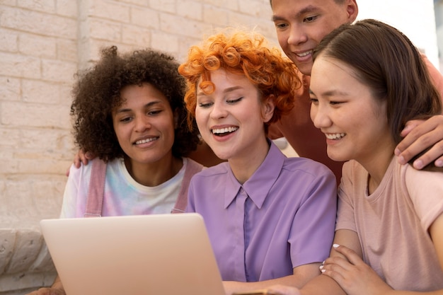 Free photo close up smiley friends with laptop