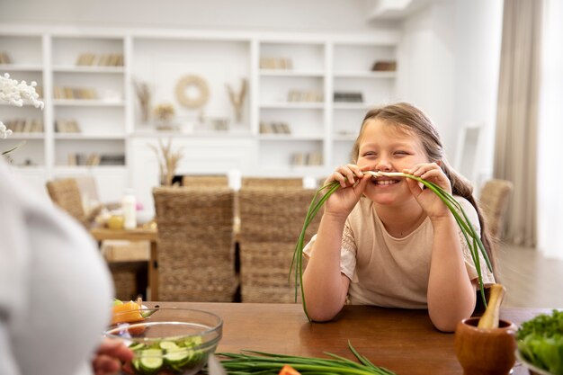 Close up smiley girl holding green onion