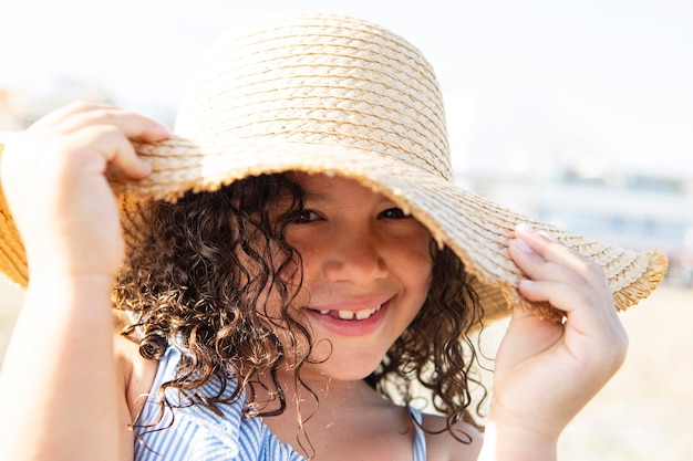 Close up smiley girl wearing hat on beach