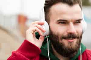 Free photo close-up smiley guy with headphones looking away