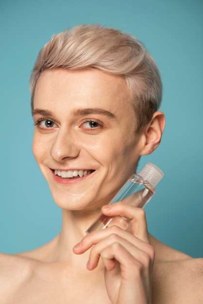 Free Photo close up smiley man holding serum