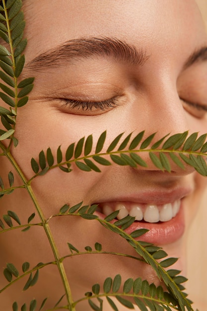 Free photo close up smiley model posing with plant