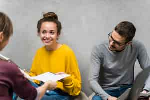 Free photo close-up smiley people studying together indoors