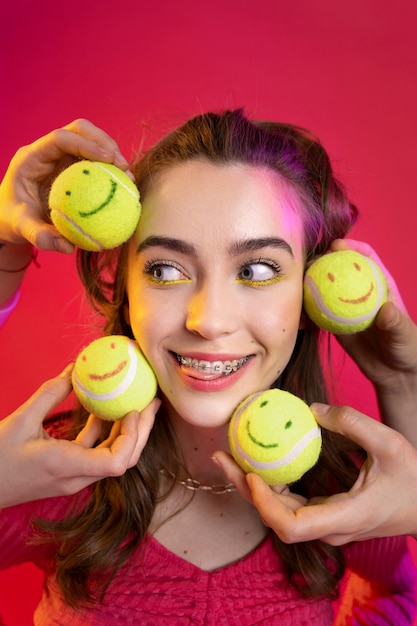 Close up smiley teenager with tennis balls