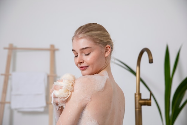 Free photo close up smiley woman holding bath sponge