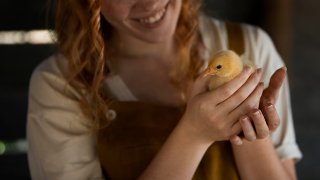 Close up smiley woman holding chicken