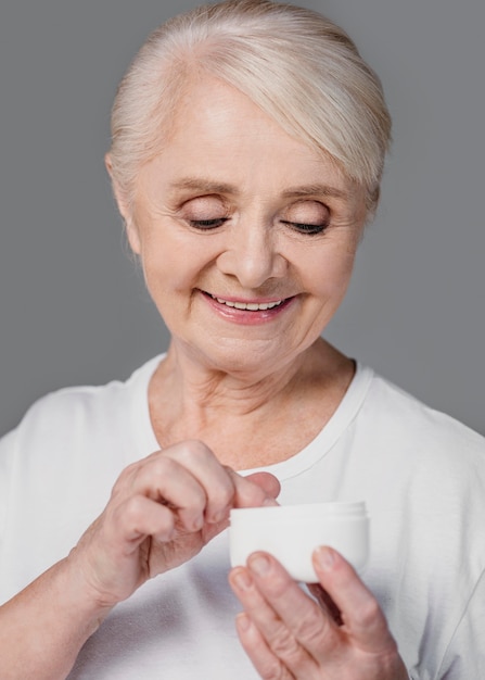 Close-up smiley woman holding cream container