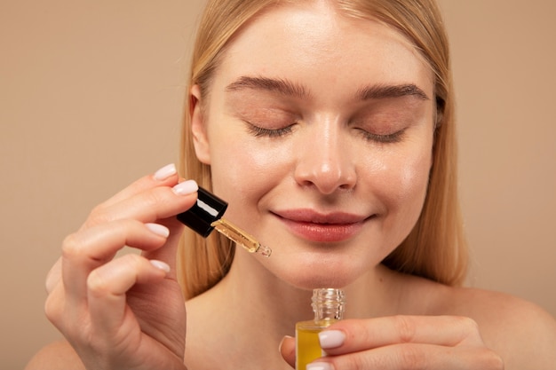 Close up smiley woman holding serum