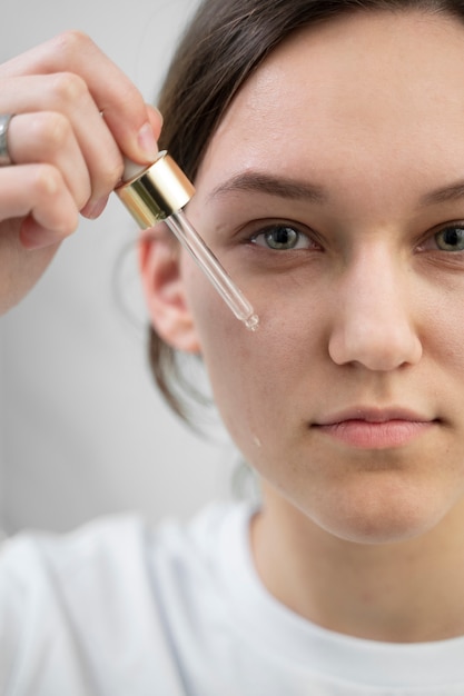 Free Photo close up smiley woman holding serum