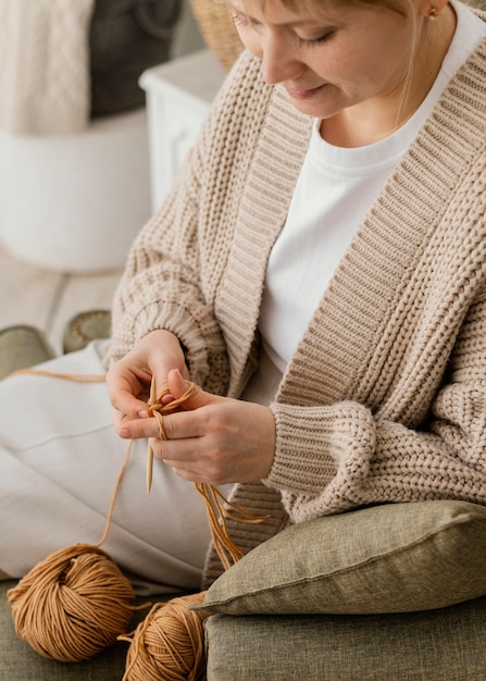 Free photo close-up smiley woman knitting