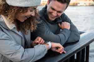 Free photo close up smiley woman and man checking watch