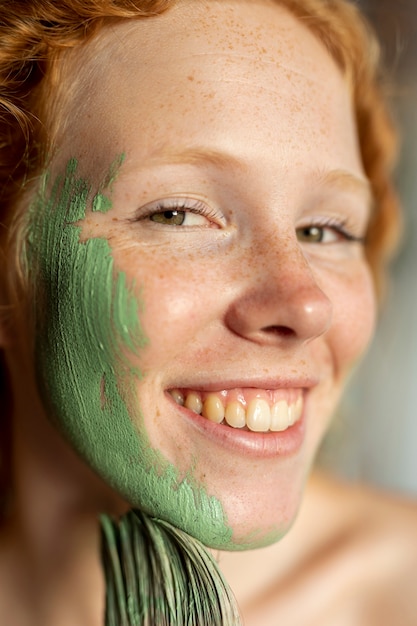 Close-up smiley woman painting her face