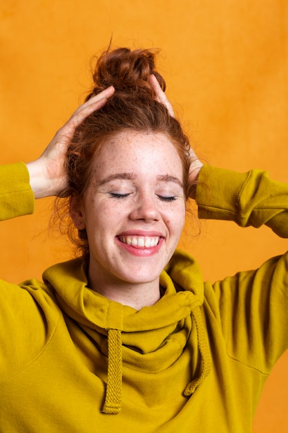 Free photo close-up smiley woman posing with yellow hoodie