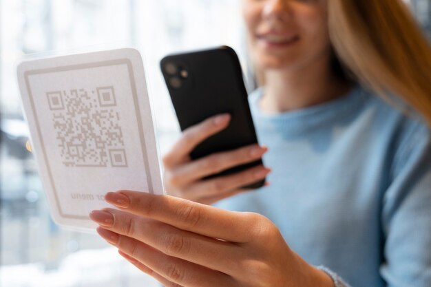 Close up smiley woman scanning qr