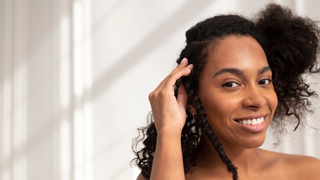 Close up smiley woman styling hair