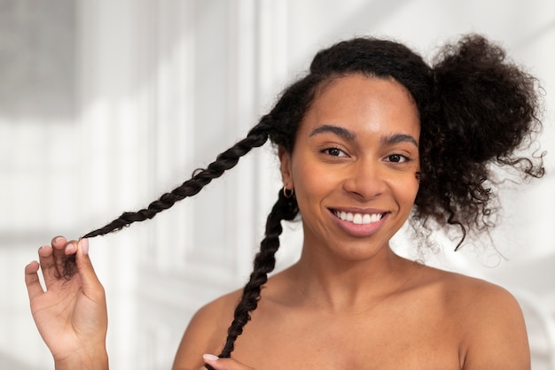 Close up smiley woman styling hair