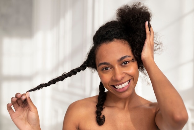 Close up smiley woman styling hair