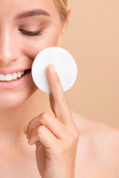 Free Photo close-up smiley woman with cotton pad 