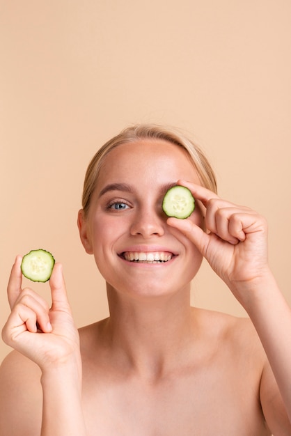 Free photo close-up smiley woman with cucumber slices