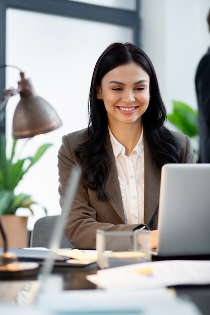 Close up smiley woman working on laptop