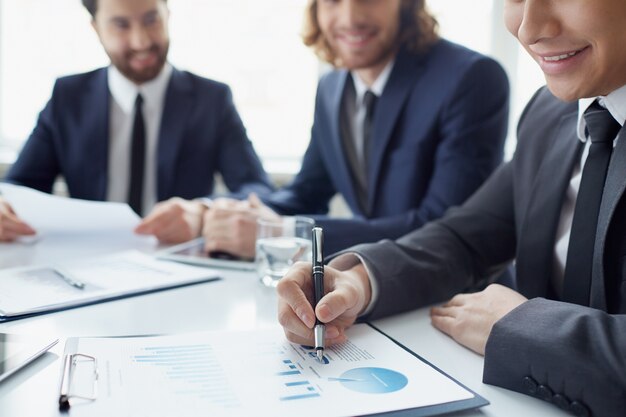 Close-up of smiling businessman analyzing a chart