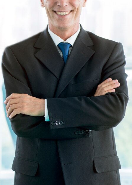 Close-up of a smiling businessman with folded arms