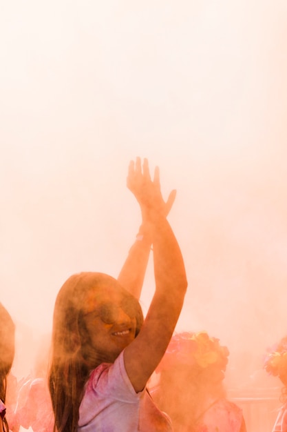 Close-up of a smiling woman dancing in the holi color