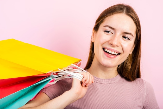 Free Photo close-up smiling woman holding bags