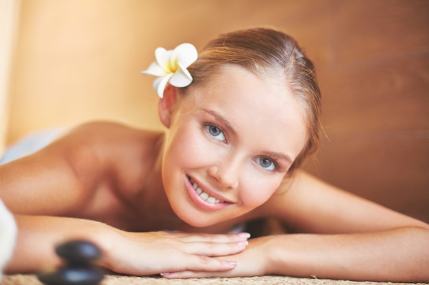 Close-up of smiling woman lying in spa