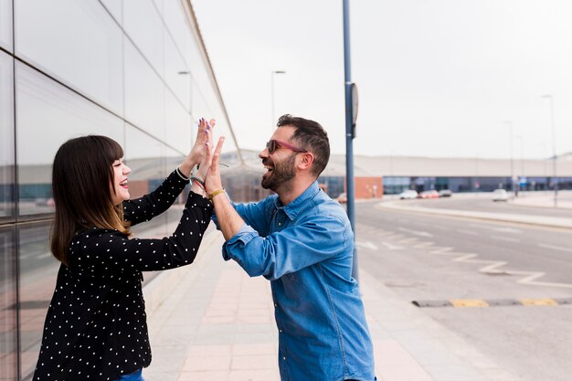 Close-up of smiling young couple tapping hands