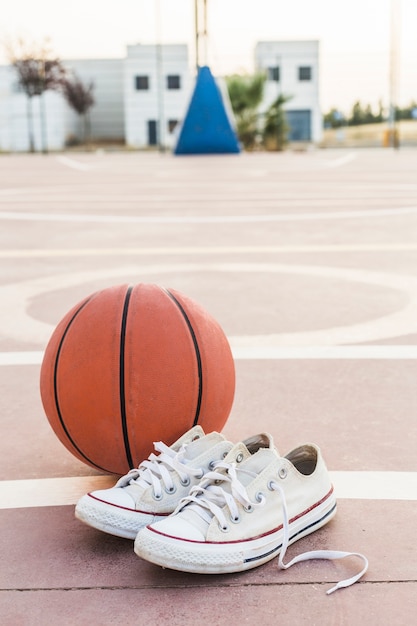 Close-up of sneakers and basketball in court