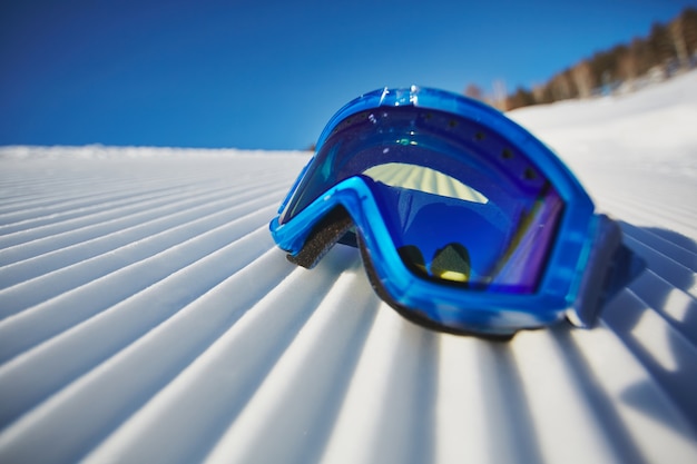 Close-up of snowboarding glasses on the snow