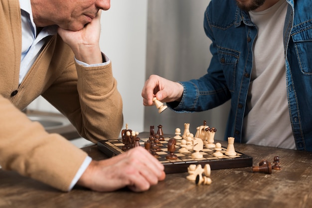 Close-up son and father playing chess