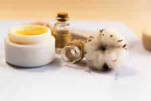 Free photo close-up of spa cream bottle with cotton flower