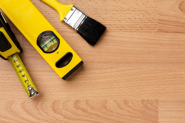 Close-up spirit level and brush on wooden background