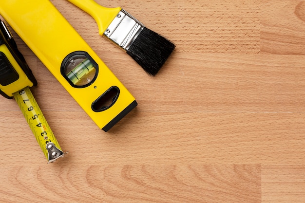 Close-up spirit level and brush on wooden background