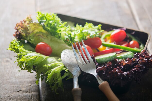 Close-up of spoon and fork with salad background