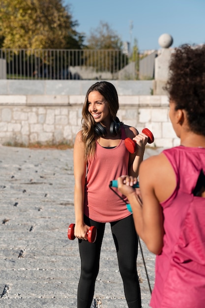 Close up sporty women with dumbbells