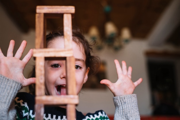 Free Photo close-up of stacked wooden blocks in front of excited girl