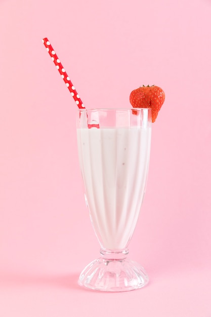 Free photo close up strawberry milkshake glass with pink background